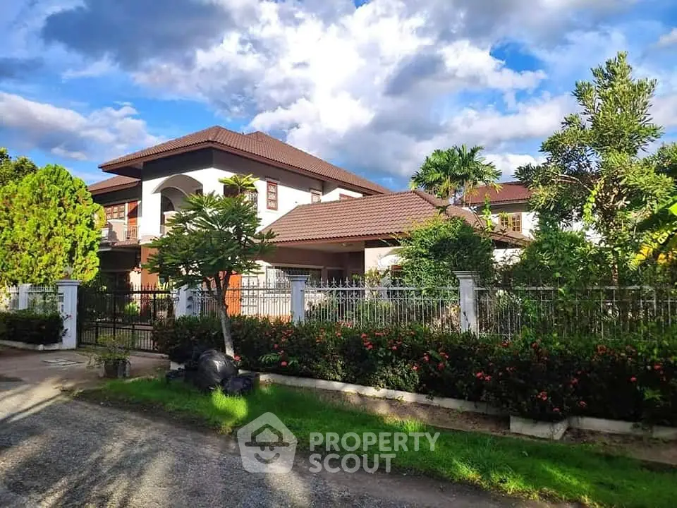 Stunning two-story house with lush garden and elegant architecture under a vibrant sky.
