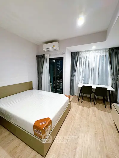 Modern bedroom with large window and stylish furniture in a cozy apartment.