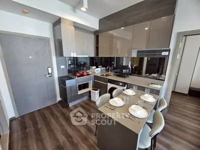 Modern kitchen with sleek cabinetry, dining table, and integrated appliances in a stylish apartment.