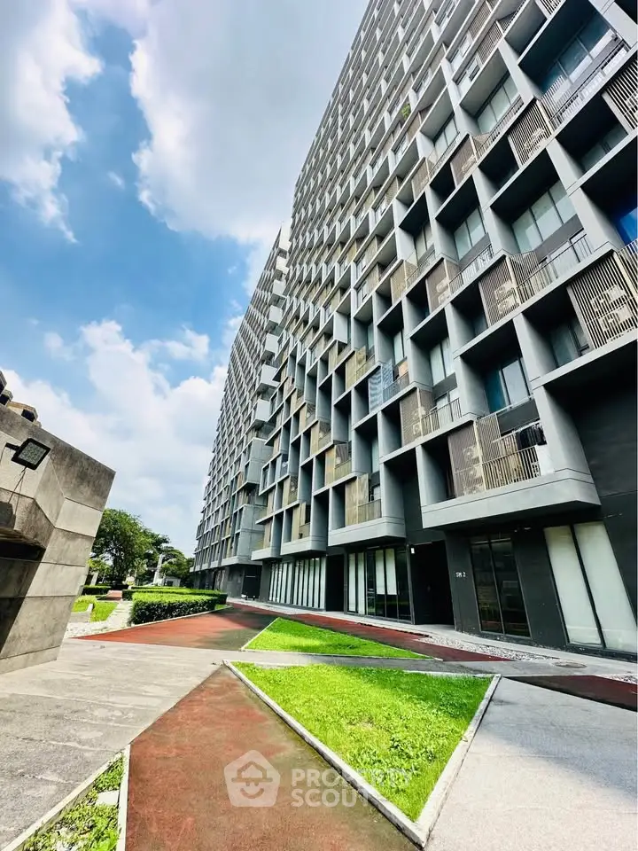 Modern architectural building exterior with unique geometric facade and lush green surroundings.