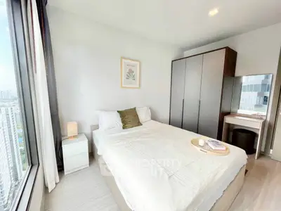 Bright modern bedroom with city view, sleek wardrobe, and cozy decor