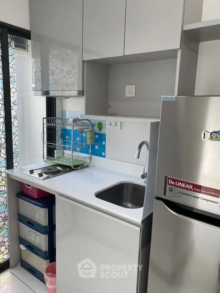 Modern compact kitchen with sleek cabinetry and stainless steel appliances, featuring a minimalist design and efficient layout.
