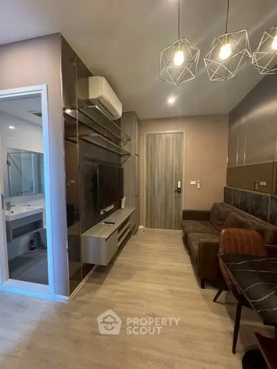 Modern living room with stylish decor and open layout, featuring a cozy sofa and contemporary lighting.