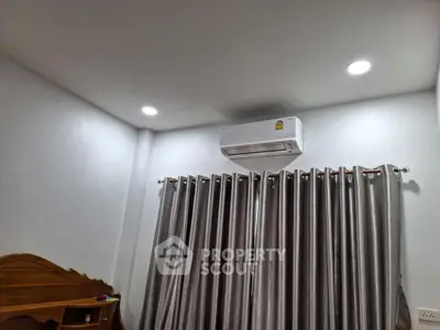 Modern bedroom with air conditioning and elegant curtains, perfect for comfort and style.