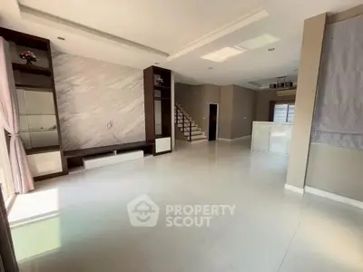 Spacious modern living room with elegant staircase and natural light