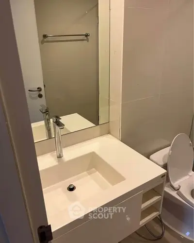 Modern bathroom with sleek sink and toilet in compact space.