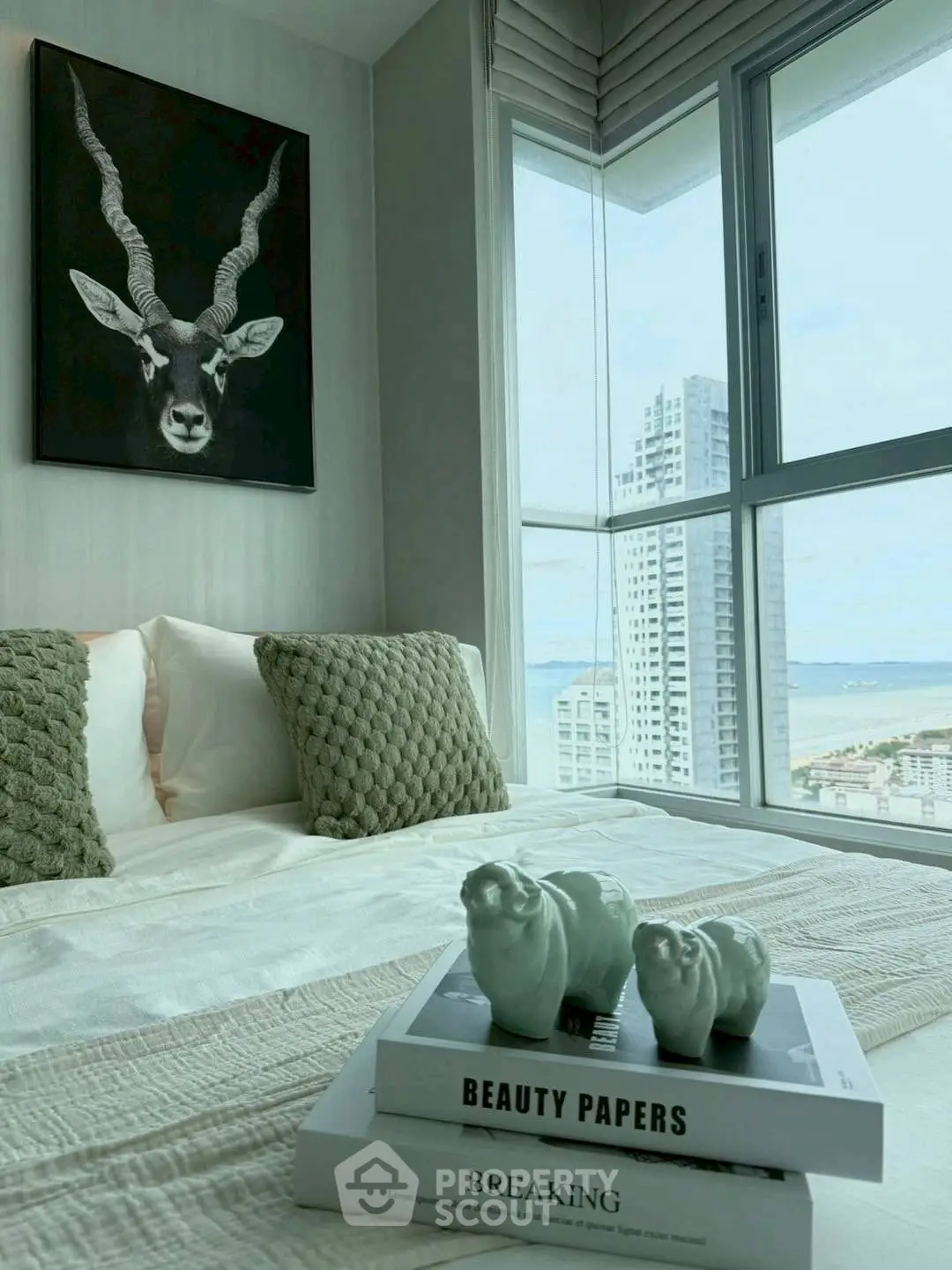 Stylish bedroom with modern decor and stunning city view from large window.