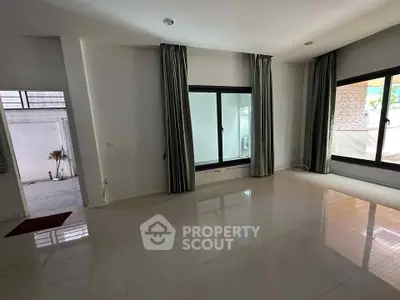 Spacious unfurnished room with large windows and glossy tile flooring