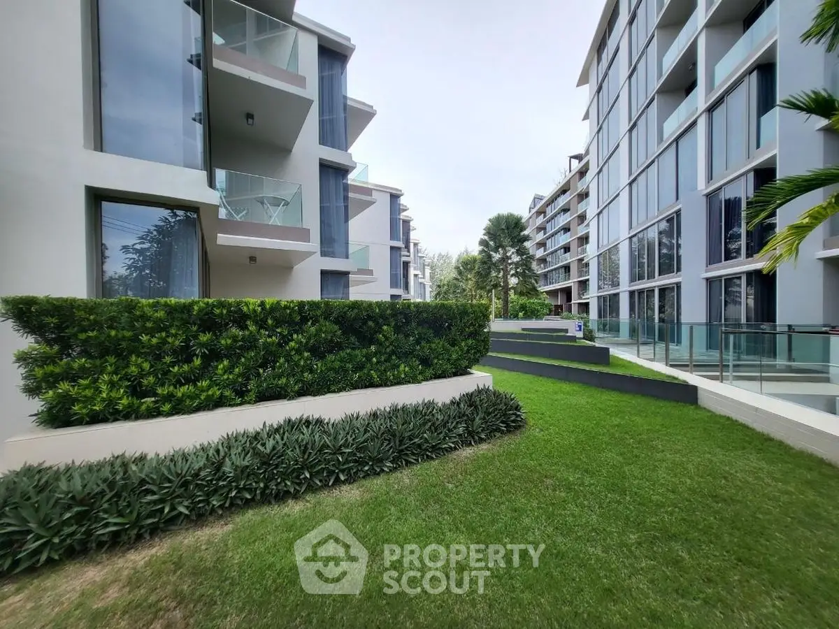Modern apartment buildings with lush green landscaping and glass balconies.