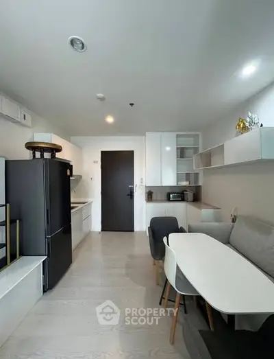 Modern kitchen and dining area with sleek design and ample storage in a contemporary apartment.