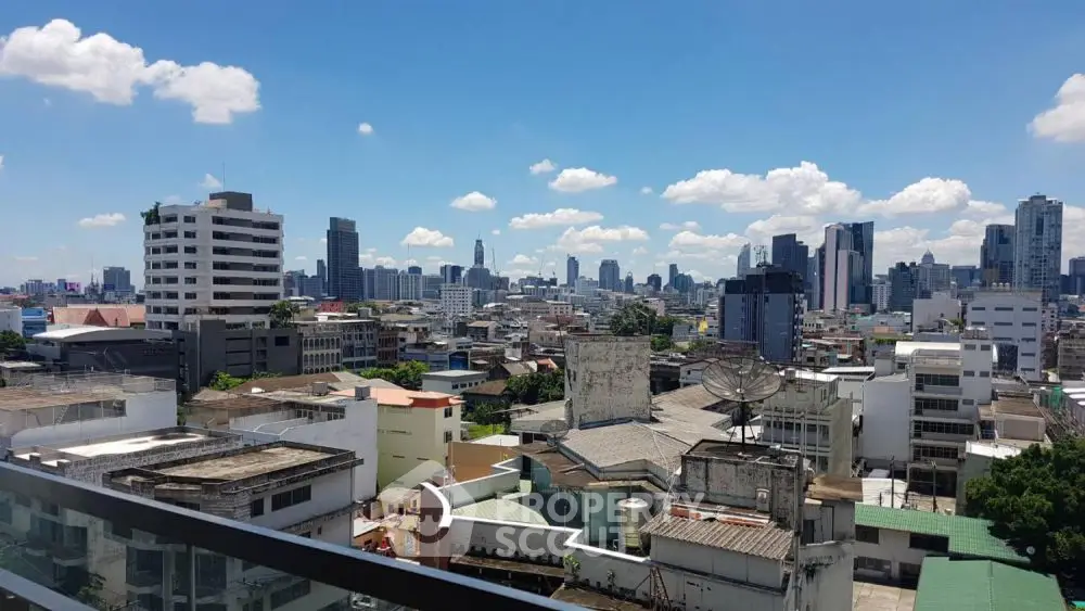 Stunning cityscape view from a high-rise balcony showcasing urban skyline under a clear blue sky.
