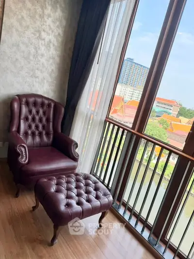 Luxurious corner unit with elegant leather armchair and ottoman, offering stunning city and river views.