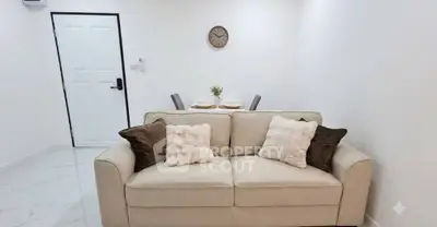 Cozy living room with plush sofa and elegant dining area in modern apartment.