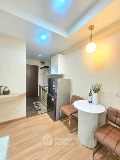 Modern kitchen with sleek design and cozy dining area, featuring stylish lighting and contemporary furniture.