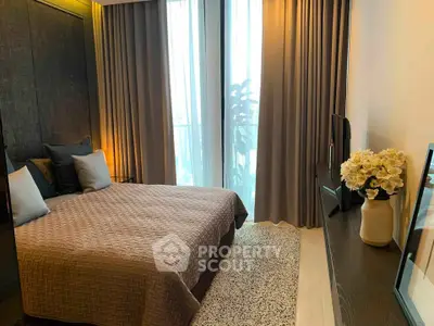 Modern bedroom with elegant decor and large window offering natural light.