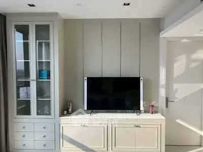 Modern living room with built-in TV cabinet and glass display shelves