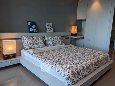 Modern bedroom with stylish decor and ambient lighting, featuring a comfortable bed and built-in storage.