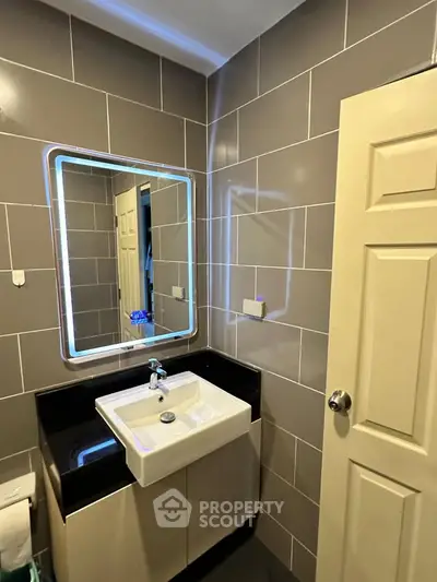 Modern bathroom with sleek sink and illuminated mirror