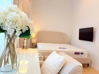 Elegant bedroom with modern decor, featuring a plush bed, stylish armchair, and a wall-mounted TV.