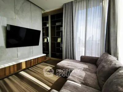 Luxurious living room with modern decor, large TV, and ample natural light from floor-to-ceiling windows.