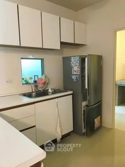 Modern kitchen with sleek white cabinets and stainless steel fridge