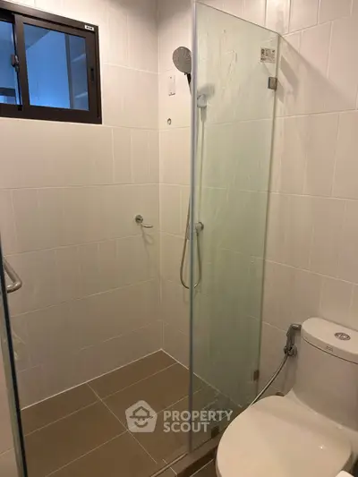 Modern bathroom with glass shower enclosure and sleek fixtures