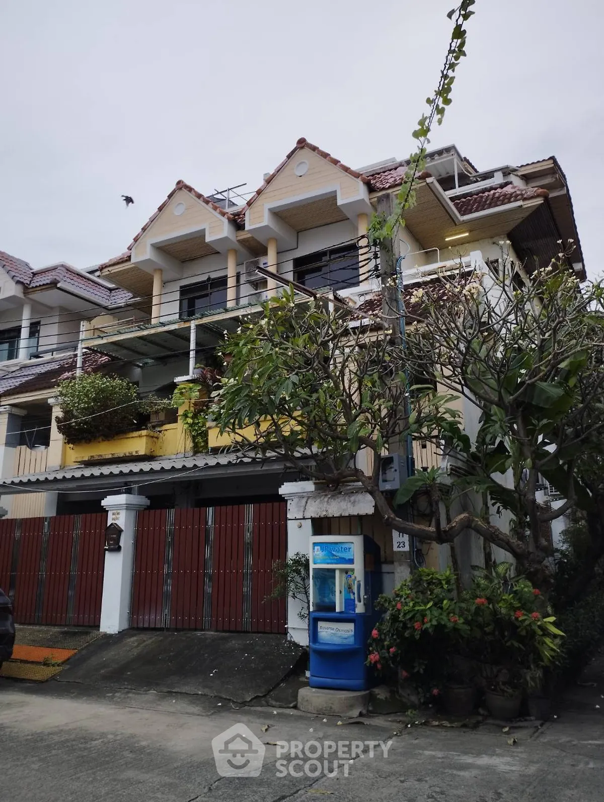 Charming multi-story house with unique roof design and lush greenery