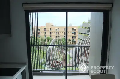 Modern apartment window with urban view and unique architectural design.