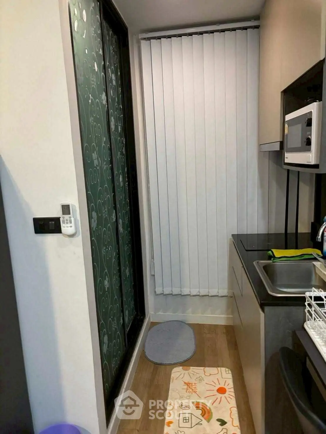 Compact kitchen with modern appliances and vertical blinds