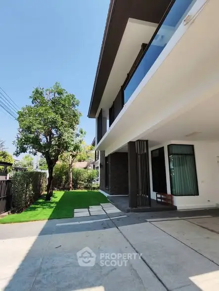 Modern two-story house with sleek design and lush green lawn, perfect for contemporary living.
