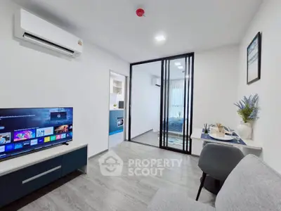 Modern living room with sleek design and open layout, featuring a TV and stylish decor.