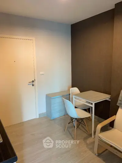 Cozy and modern studio apartment with a minimalist design, featuring a compact dining area and ample natural light, perfect for urban living.
