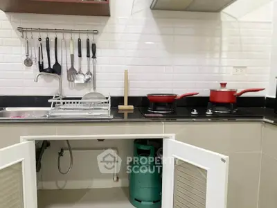 Modern kitchen with gas stove and sleek white tiles