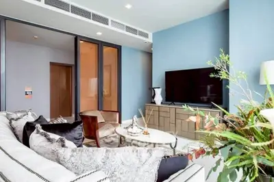 Modern living room with stylish decor and large TV, featuring elegant furniture and a cozy atmosphere.