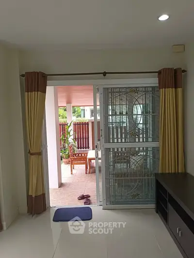 Spacious living room with sliding glass doors opening to a cozy outdoor patio area.