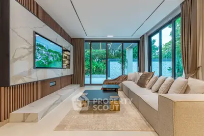Luxurious living room with modern decor and large windows overlooking a lush garden.