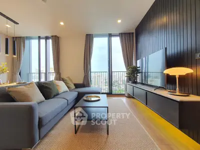 Modern living room with large windows and stylish decor in a high-rise apartment.