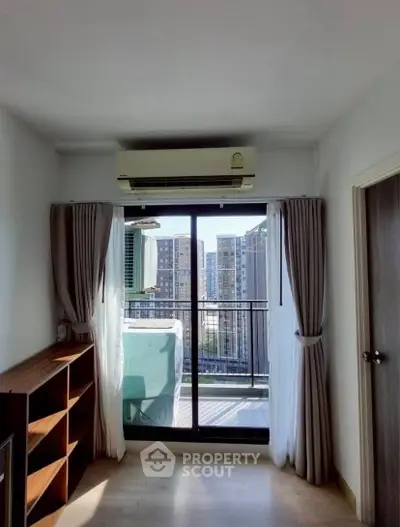 Bright room with balcony and city view, featuring air conditioning and modern decor.