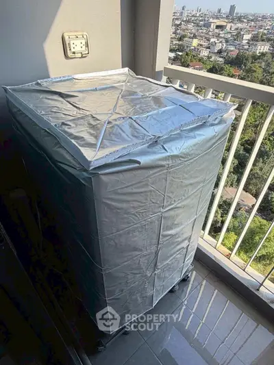 Spacious balcony with city view and covered appliance, ideal for urban living.