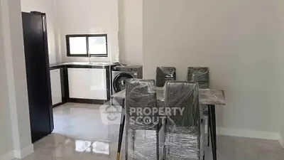 Modern kitchen with dining area featuring sleek appliances and contemporary furniture.