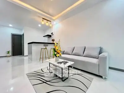 Modern living room with sleek furniture and stylish lighting in open layout.