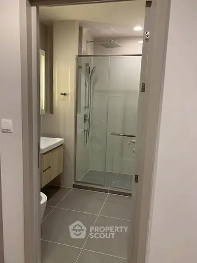 Modern bathroom with glass shower enclosure and sleek fixtures