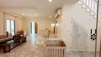 Spacious living area with marble flooring and modern furnishings in a stylish home.