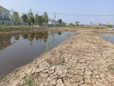 Vacant land with waterlogged areas and dry patches, potential for development.