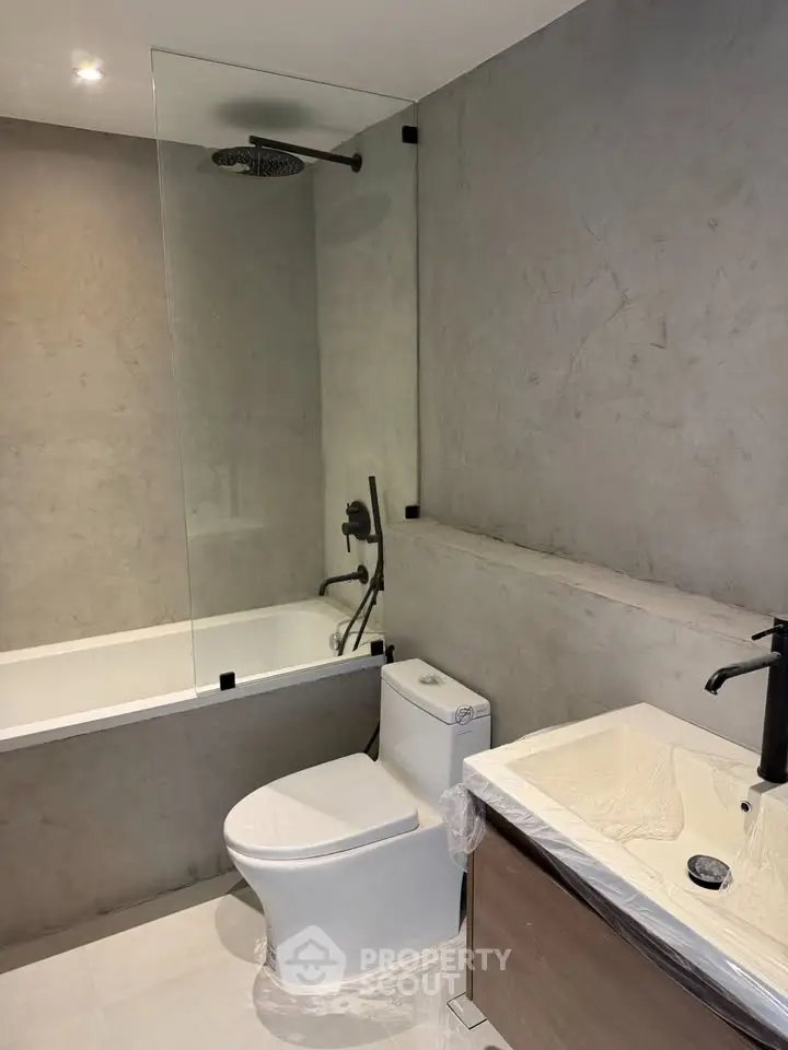Modern bathroom with sleek design, featuring a bathtub and stylish fixtures.