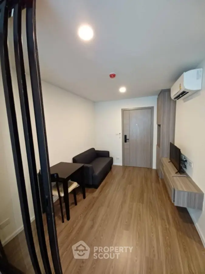 Modern living room with sleek furniture and wooden flooring in a stylish apartment.