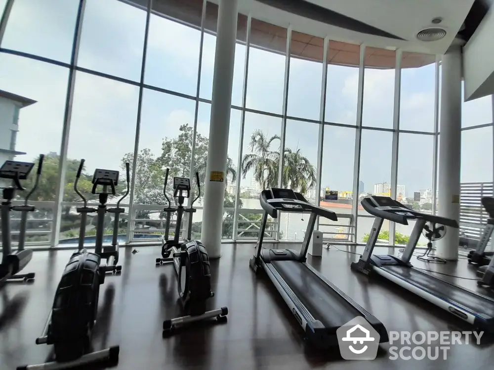 Spacious gym with modern equipment and panoramic city view