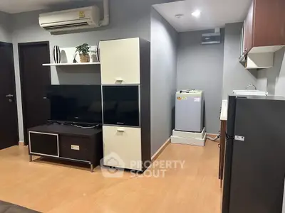 Modern living room with sleek furniture and built-in appliances in a stylish apartment.