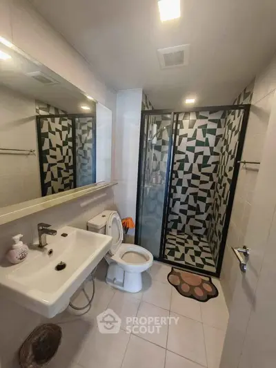 Modern bathroom with geometric tile shower and sleek fixtures