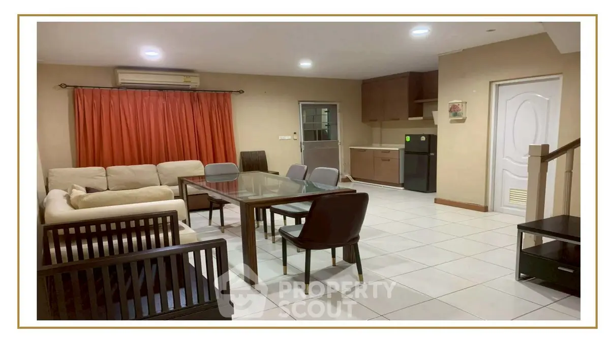 Spacious living room with modern furniture and open kitchen layout, perfect for family gatherings.